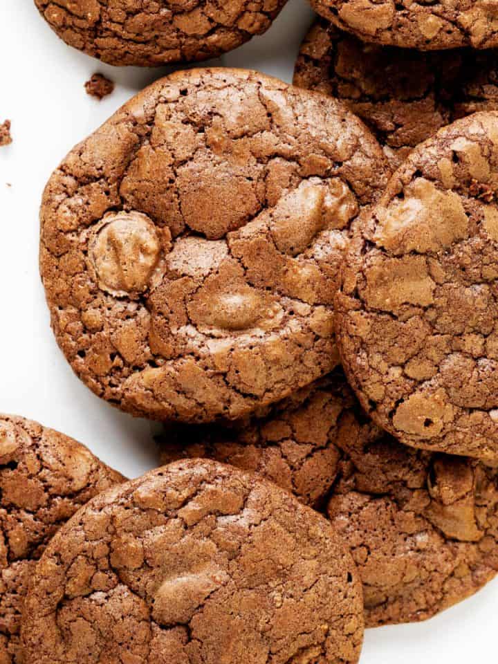 Brownie cookies in a pile on a white surface. Close up image.