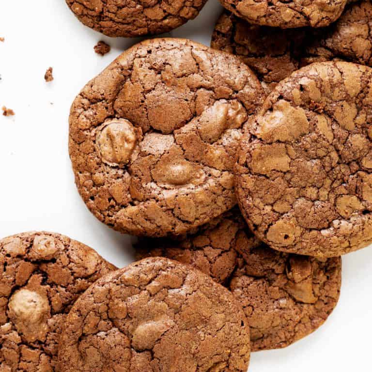 Brownie cookies in a pile on a white surface. Close up image.