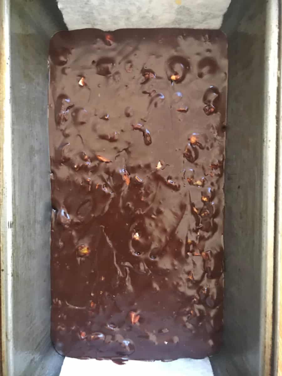 Metal loaf pan with dark chocolate fudge mixture
