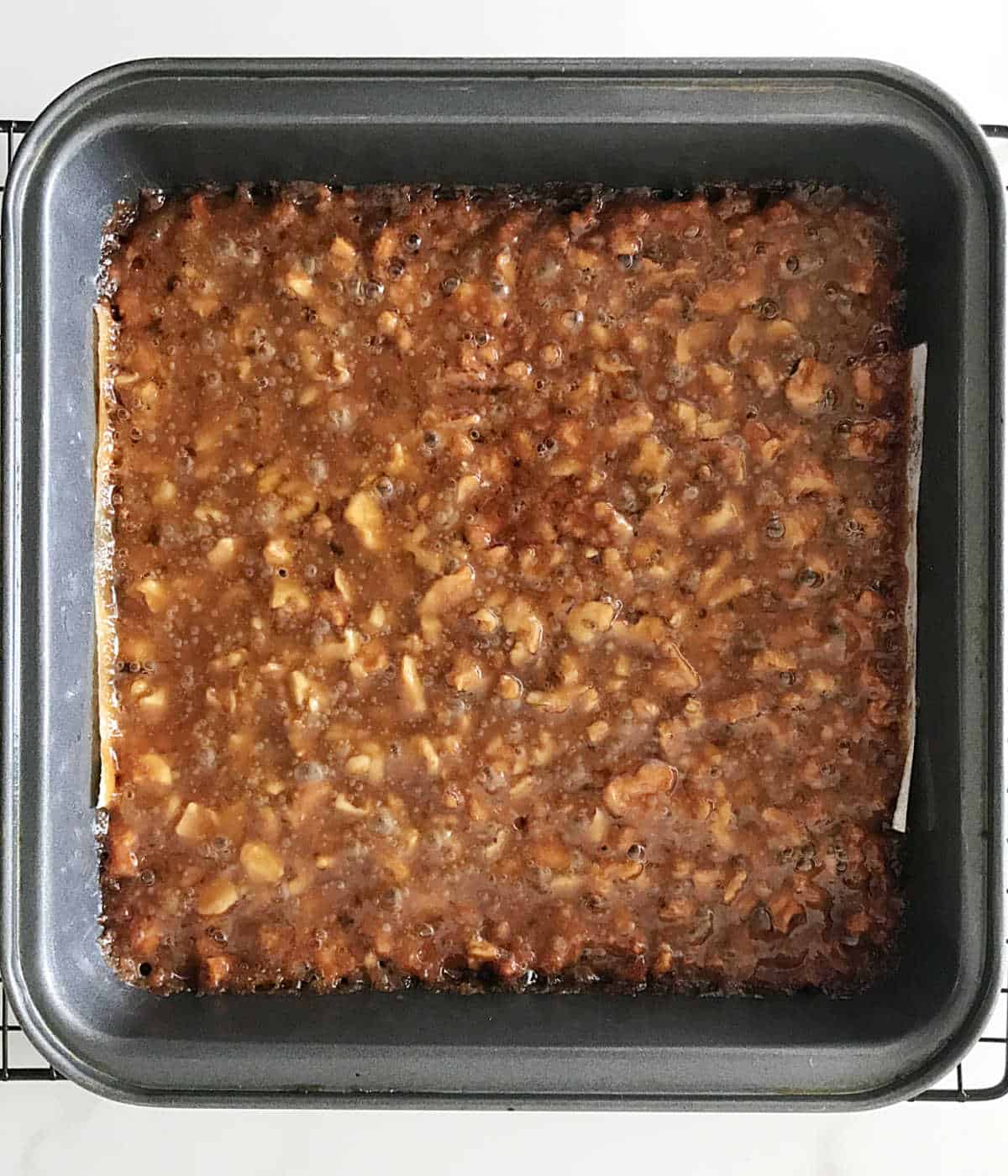 Baked walnut honey bars in a square metal pan.