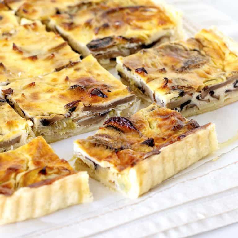 White cloth with several squares of mushroom quiche.