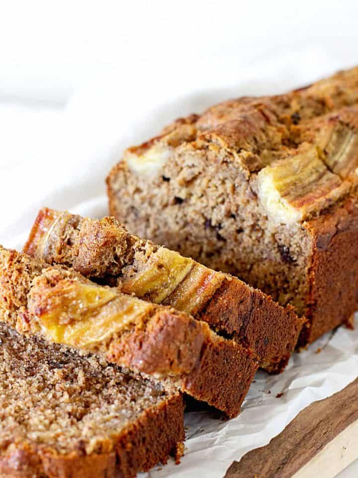 Sliced banana bread loaf on parchment paper