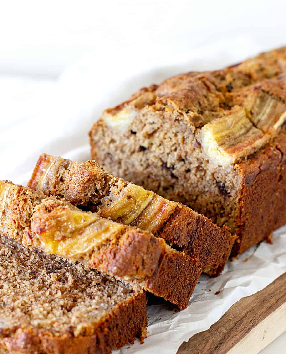 Sliced banana bread loaf on parchment paper