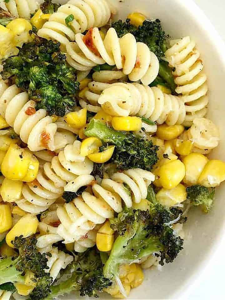 Broccoli corn pasta in a white bowl. Close up image.