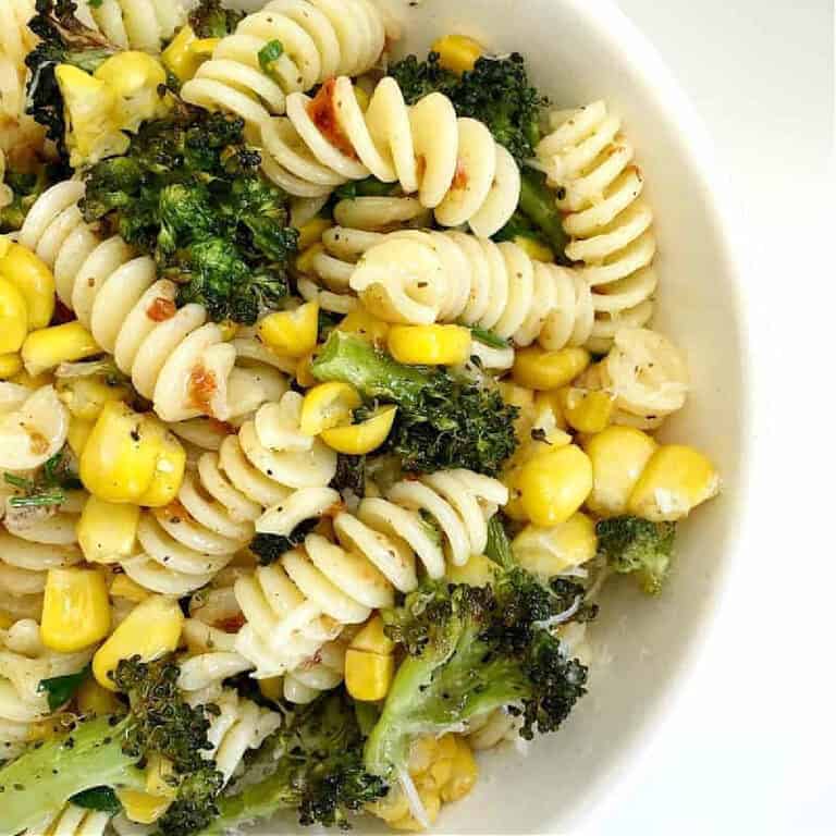 Broccoli corn pasta in a white bowl. Close up image.