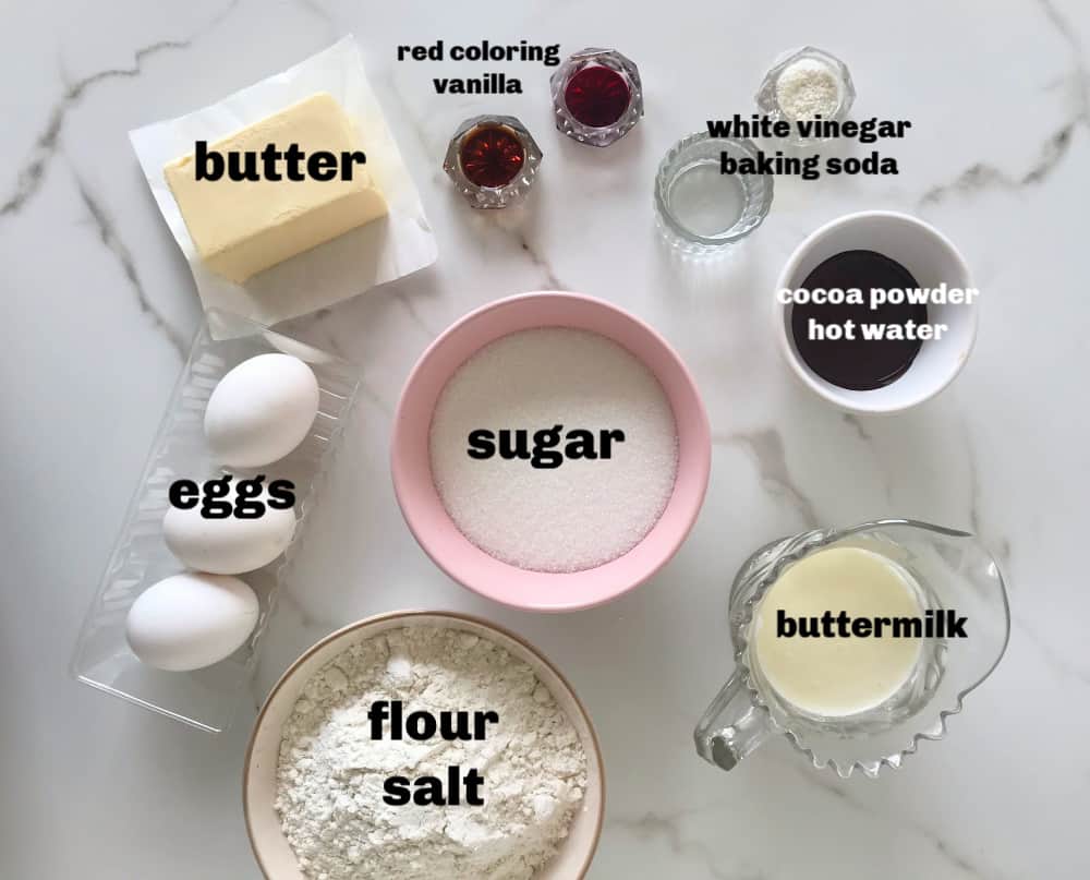 Red velvet cake ingredients in bowls on marble surface