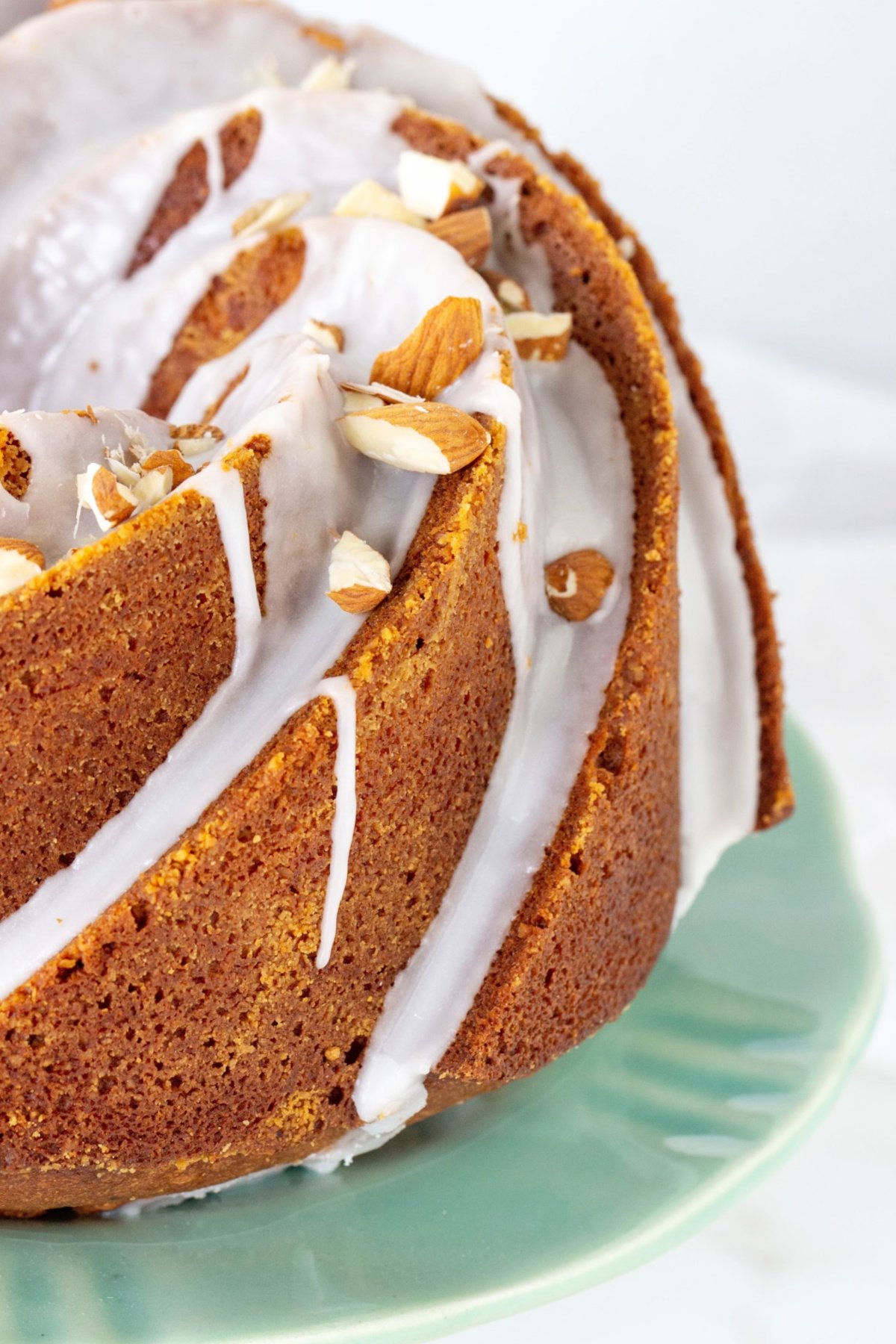 Partial view of glazed bundt cake on green plate