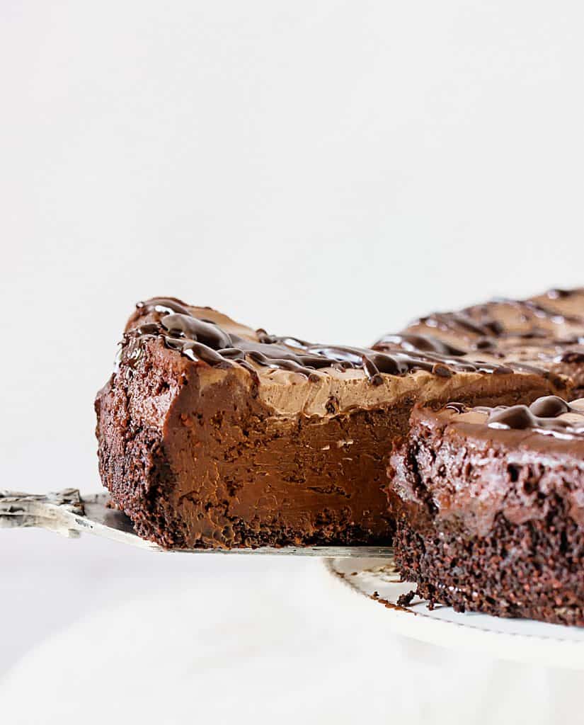 Pulling out slice of chocolate cheesecake with cake server