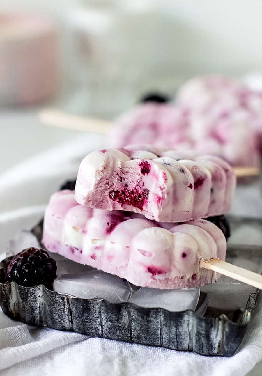 White and magenta popsicles, metal long pan, light colored props on background