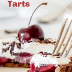 Forking bite of cherry cream tart on white plate