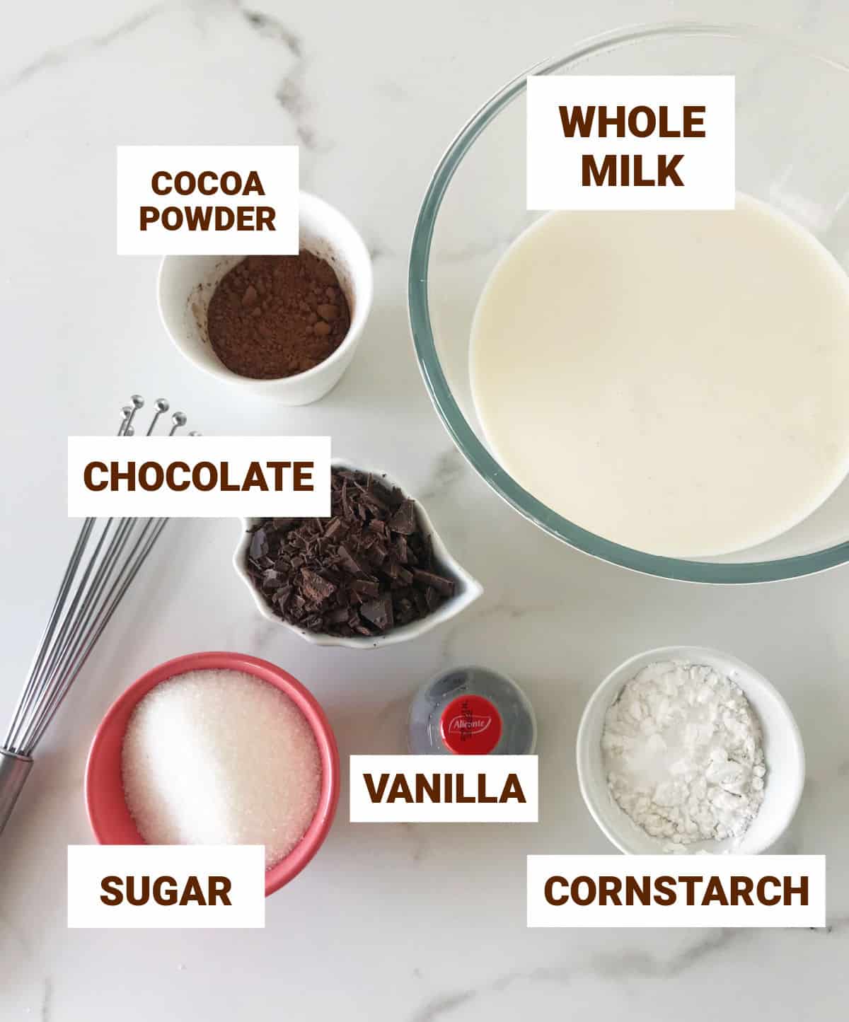 Chocolate pudding ingredients in bowls on white marble surface