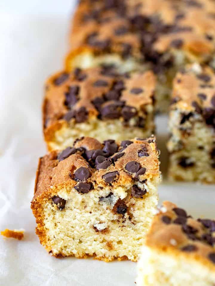 Squares of vanilla cake with chocolate chips on parchment paper