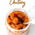 Glass jar with peach chutney, silver spoon inside, image with text