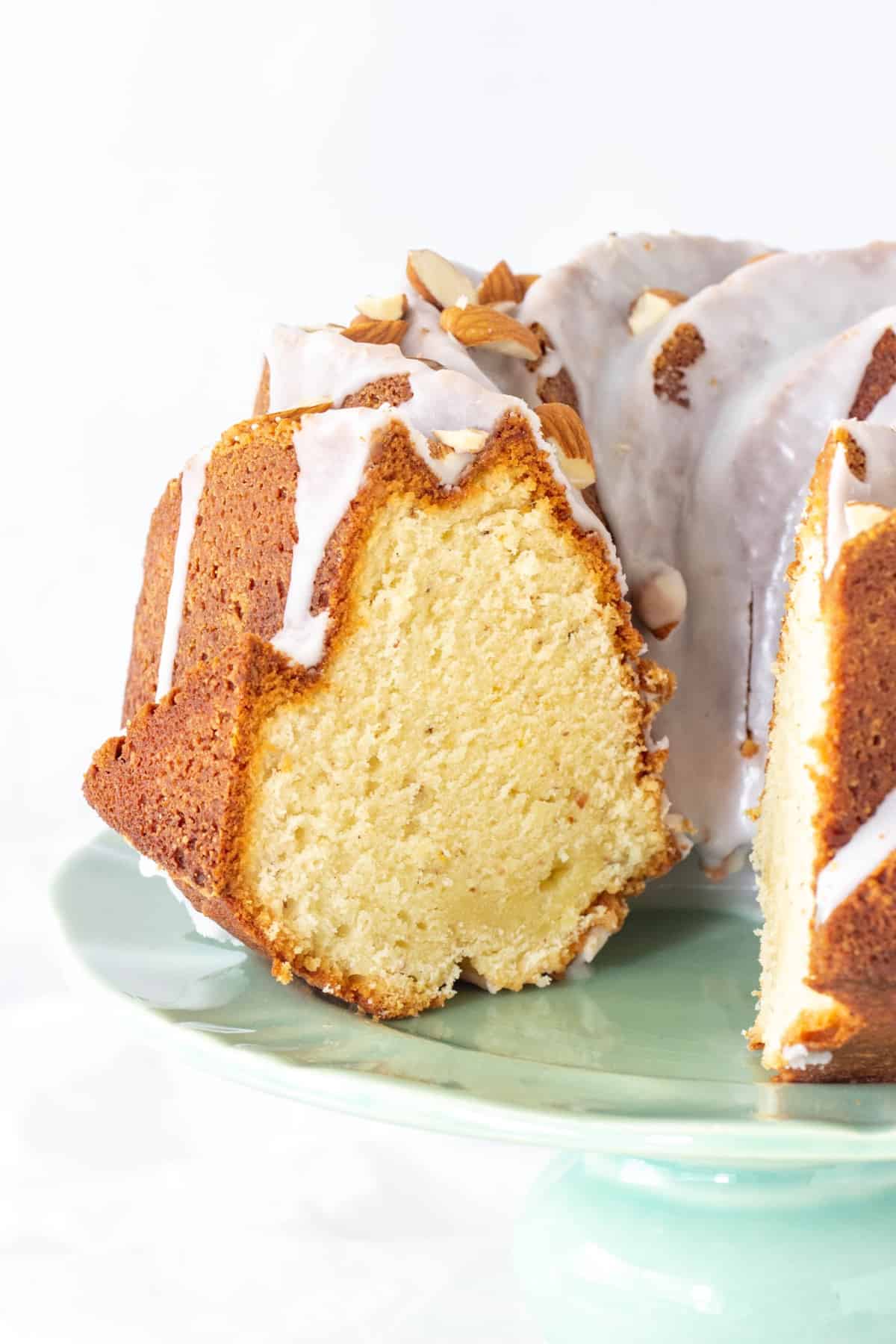 Cut glazed bundt cake on a green cake stand