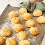 Metal tray with baked scones; hand holding it with a green kitchen towel. Text overlay.