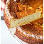 Hands taking a slice of ricotta cheesecake from whole cake, white background
