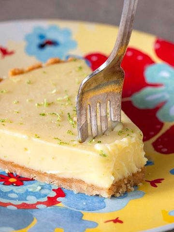 Slice of lime pie and fork on colorful plate