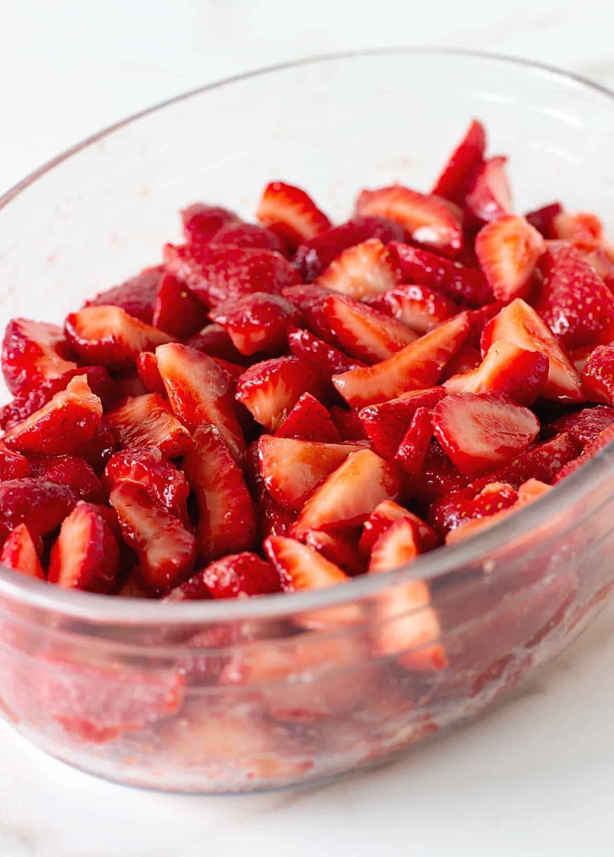 Glass oval dish with cut-up strawberries