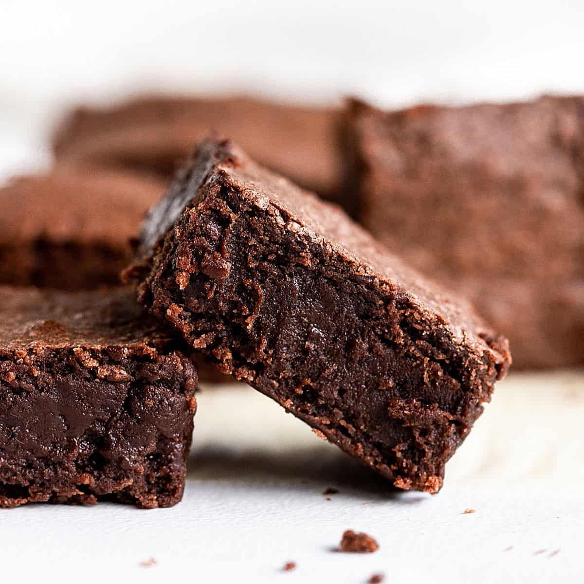 Plain brownie squares on a white surface.