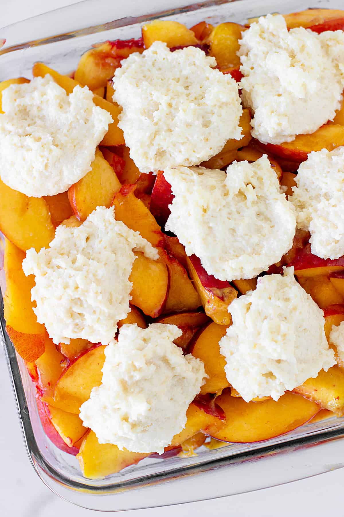 Glass dish with peaches and raw biscuit topping