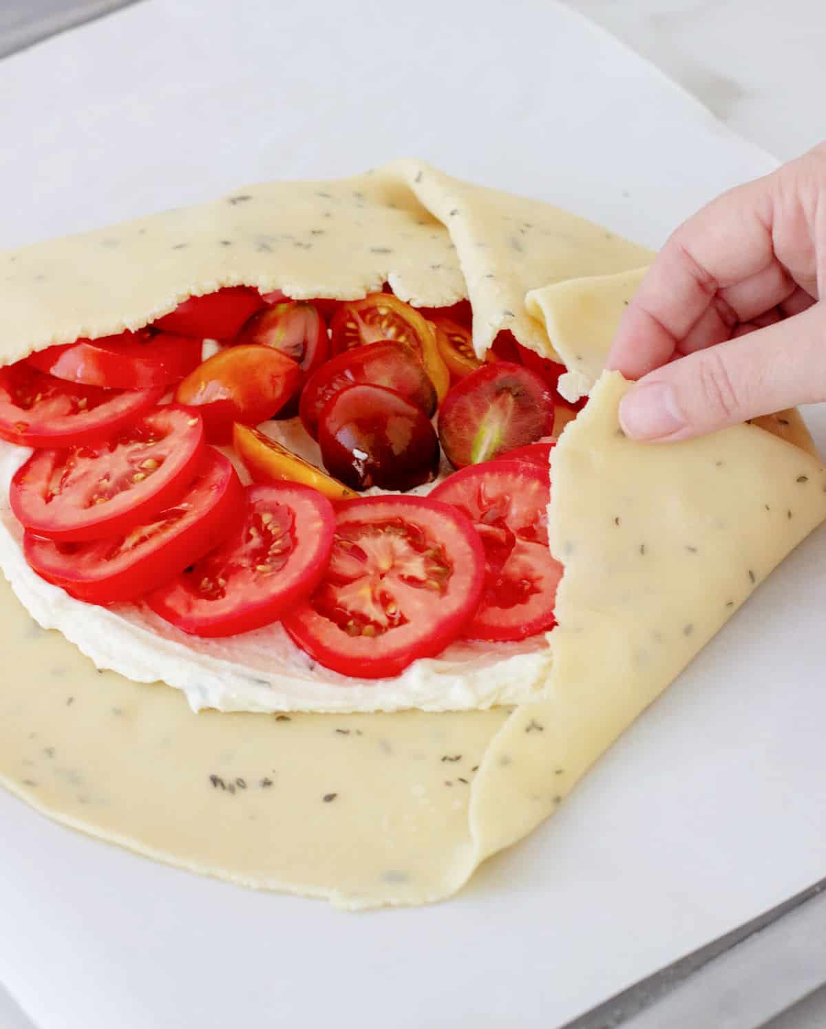 Premium Photo  Homemade galette or savory pie with red and yellow tomatoes  and basil on old newspaper or parchment paper. top view.