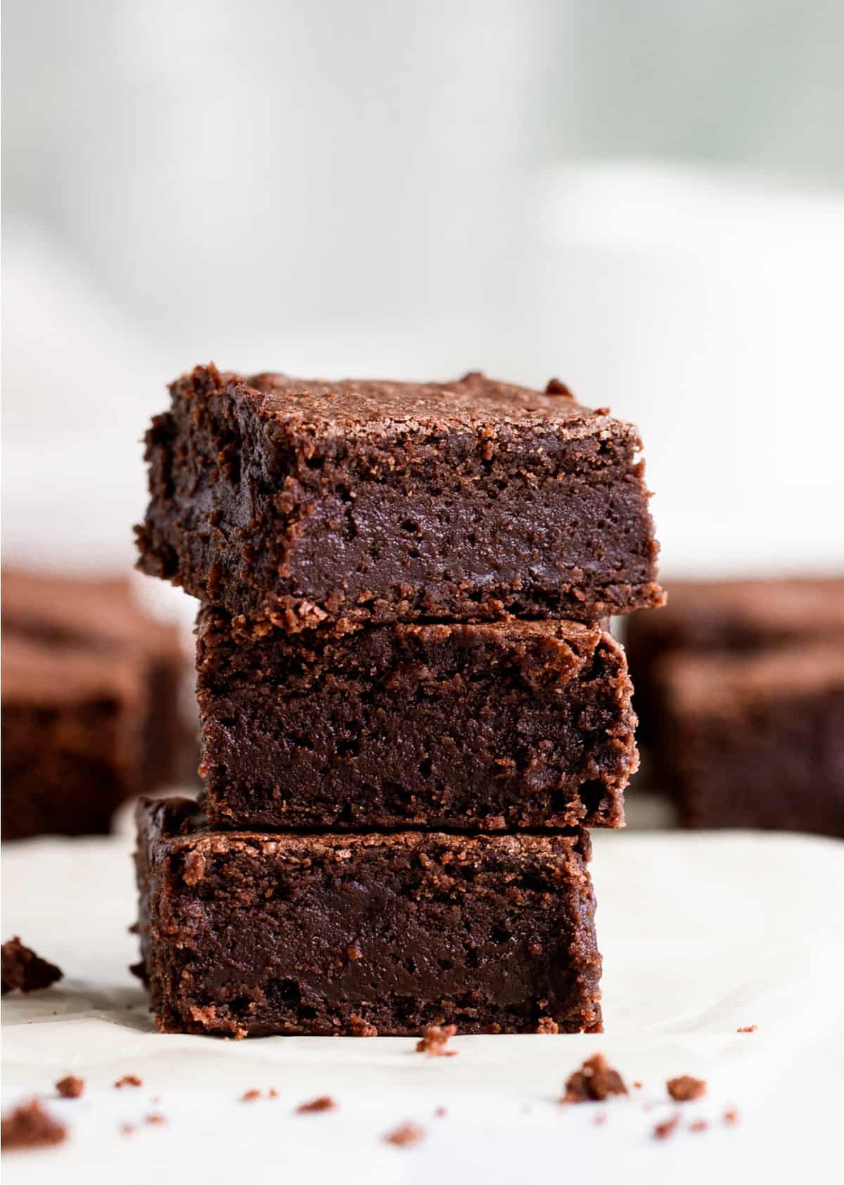 Stack of three brownies on white surface