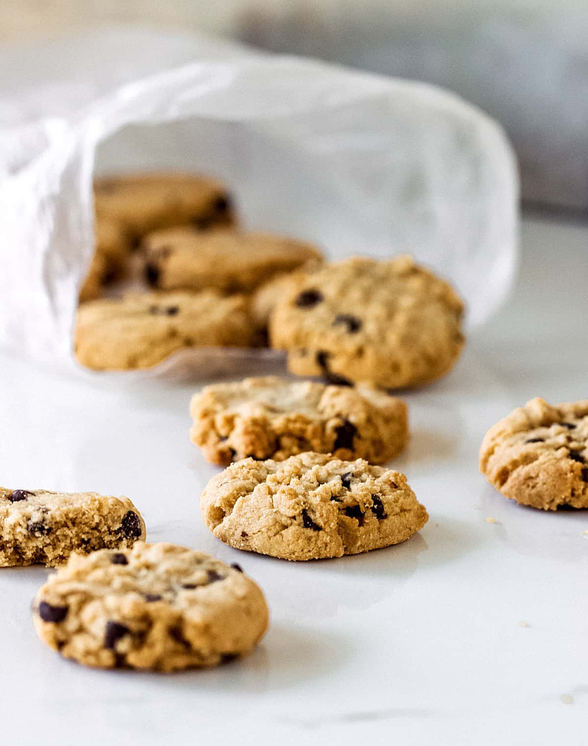 Cookies coming out of a plastic bag on a white surface.