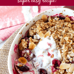 Overview of white oval dish with cherry crumble, silver spoon, pink background; image with text