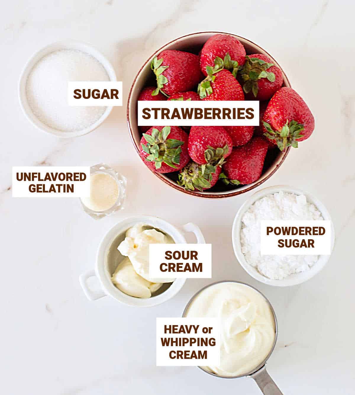 Bowls with ingredients for strawberry tart filling including cream, sugar, sour cream, gelatin. White surface.
