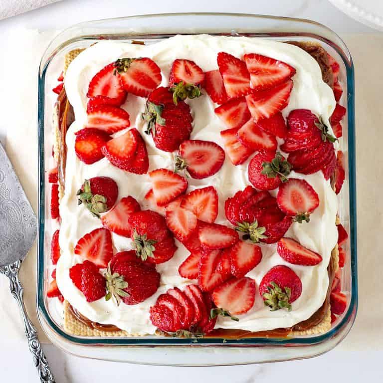 Serving on strawberry icebox cake on vintage cake server, greyish background