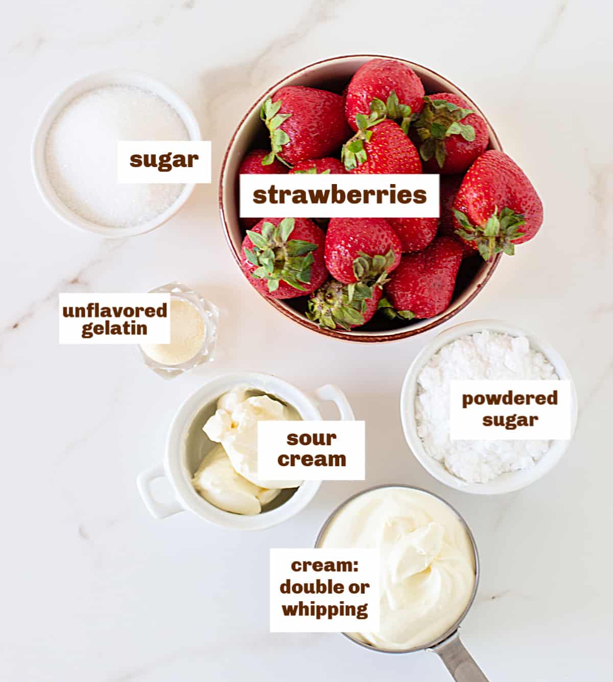 Bowls with strawberries, cream and sugars on a white table