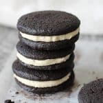 Three homemade oreo cookies stacked on a grey countertop