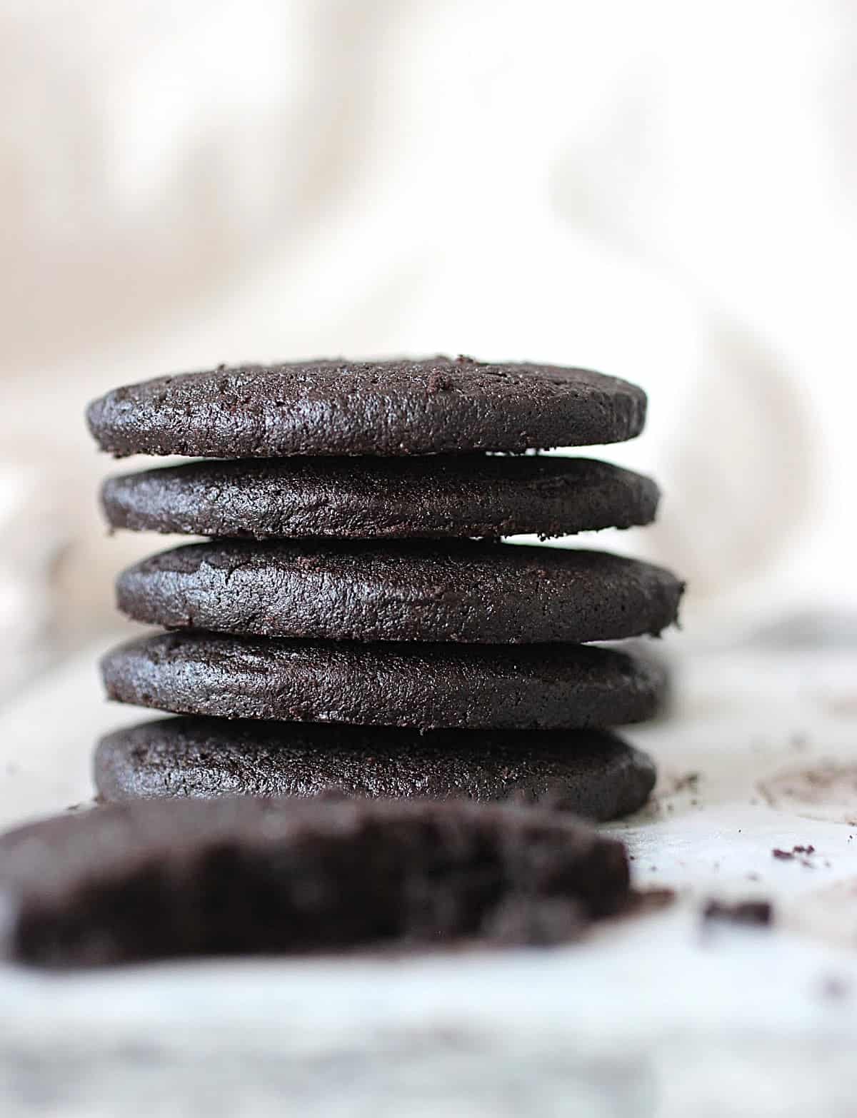 Stack of several chocolate cookie rounds, light colored background