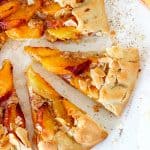 View of half peach galette slices on a white table