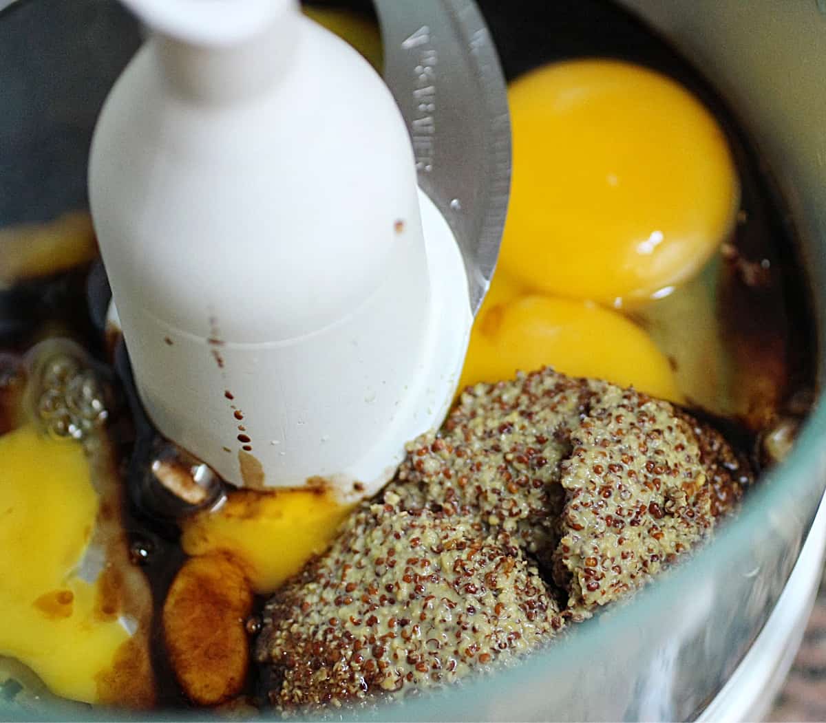 Close-up of food processor bowl with eggs and grain mustard.