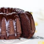 Removing slice from glazed chocolate bundt cake.