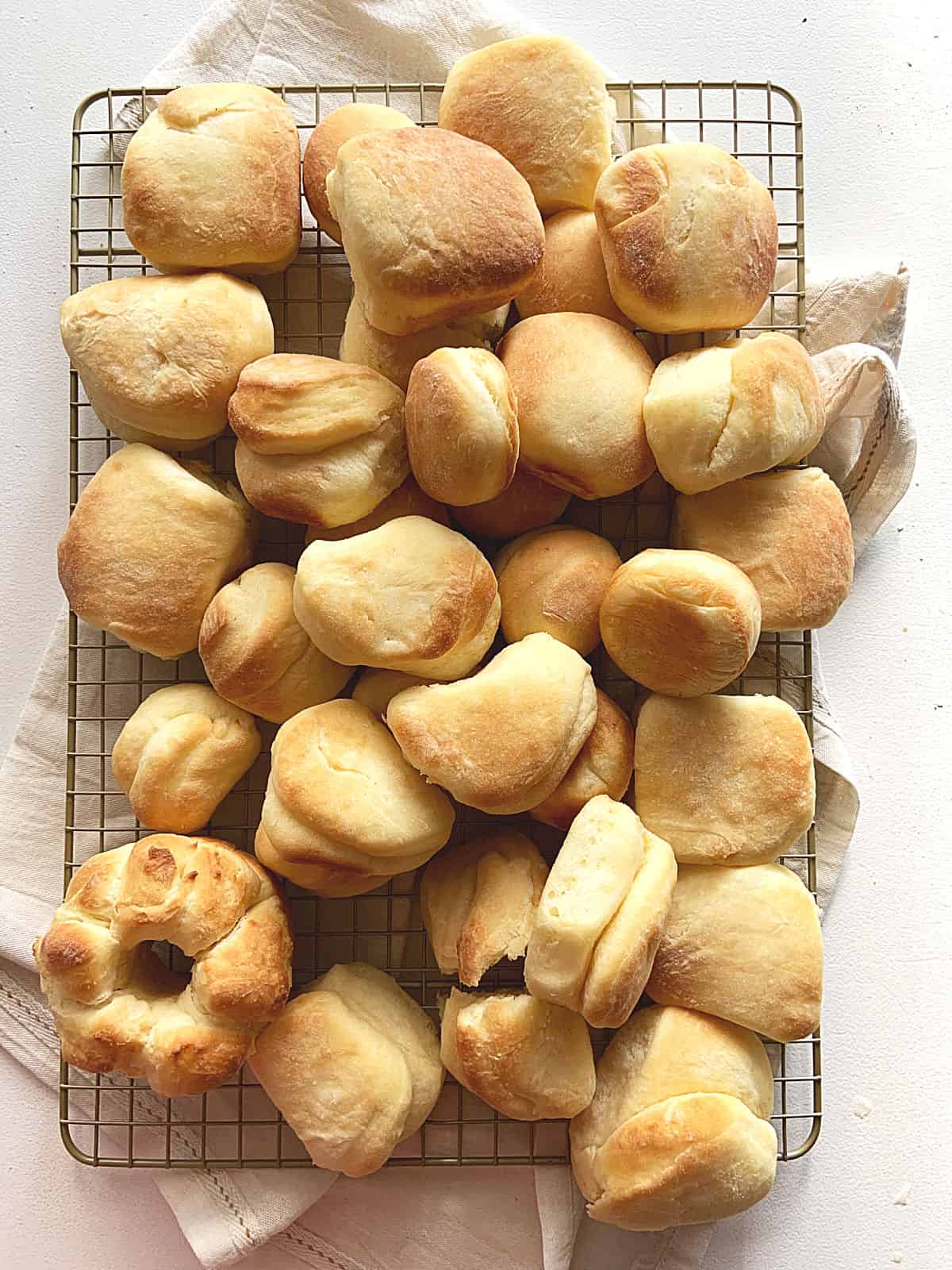 Top view of rectangular wire rack with golden dinner rolls of different sizes