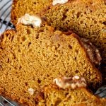 Close up of slices of pumpkin bread on a wire rack, image with text