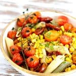 Close up of pasta cream and gold bowl with corn and tomatoes