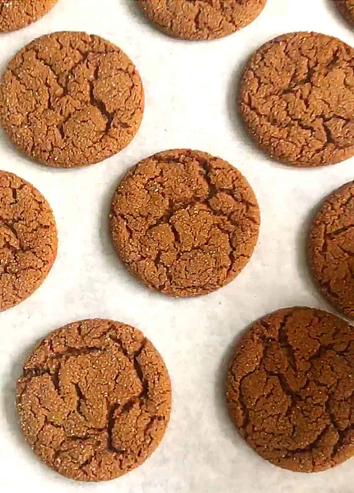 Top view of ginger crinkle cookies on white paper
