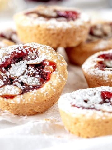 Several raspberry jam tarts on white background