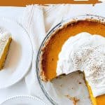 Top view of eaten pumpkin pie in glass dish, white background, text and brown overlay