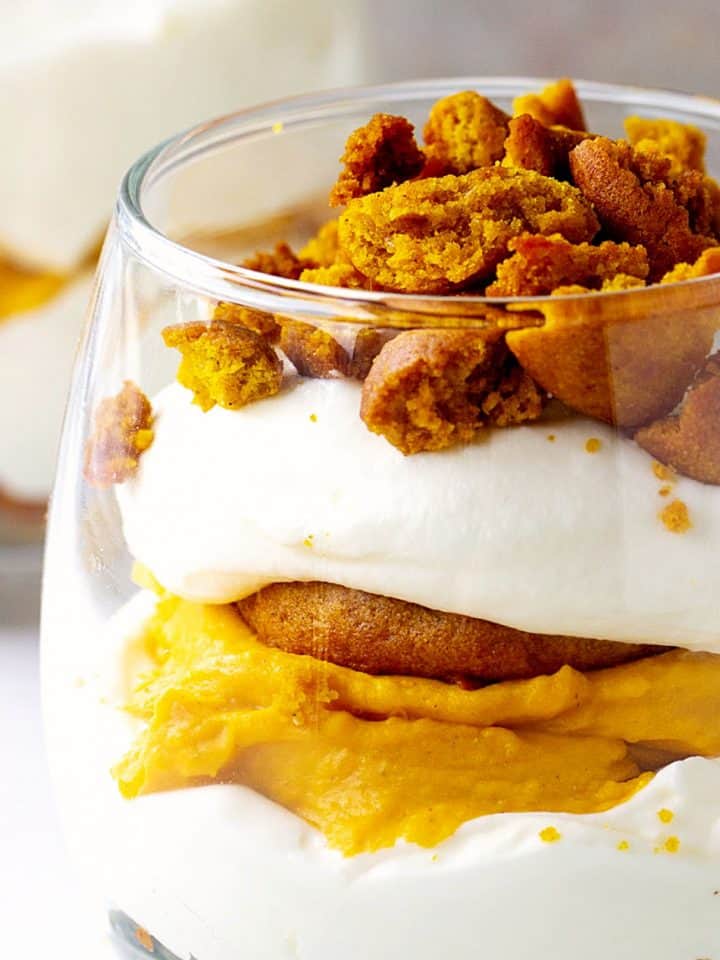 Partial close-up view of pumpkin trifle with whipped cream in a glass