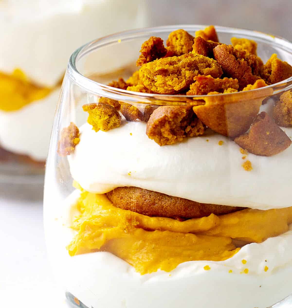 Partial close-up view of pumpkin trifle with whipped cream in a glass