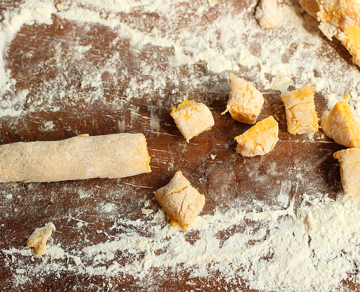 Floured wooden table with unbaked pumpkin ricotta gnocchi 