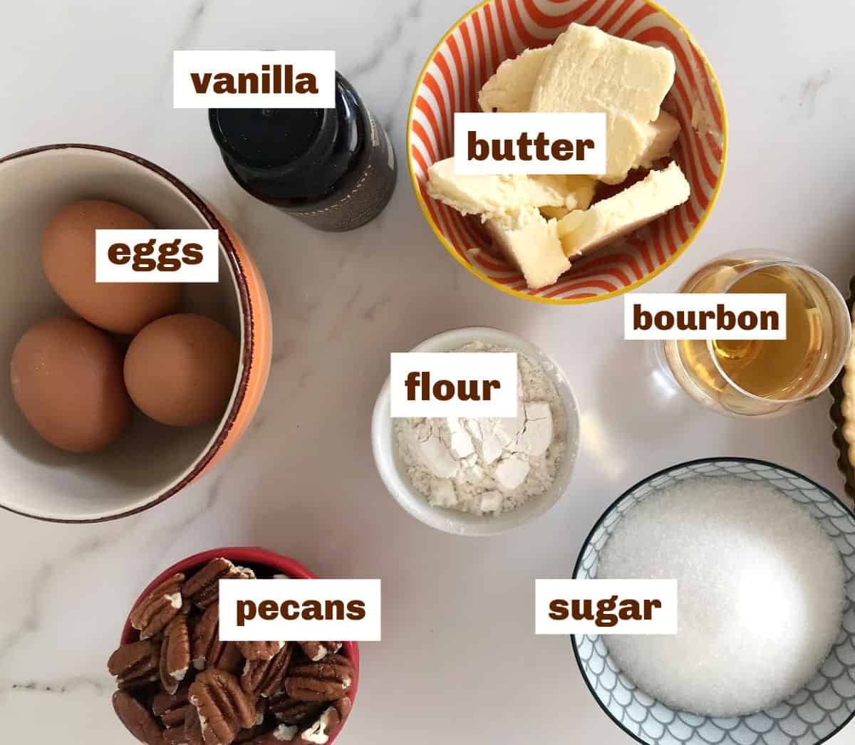 Bourbon Pecan Pie ingredients.in bowls on white surface, text with overlay