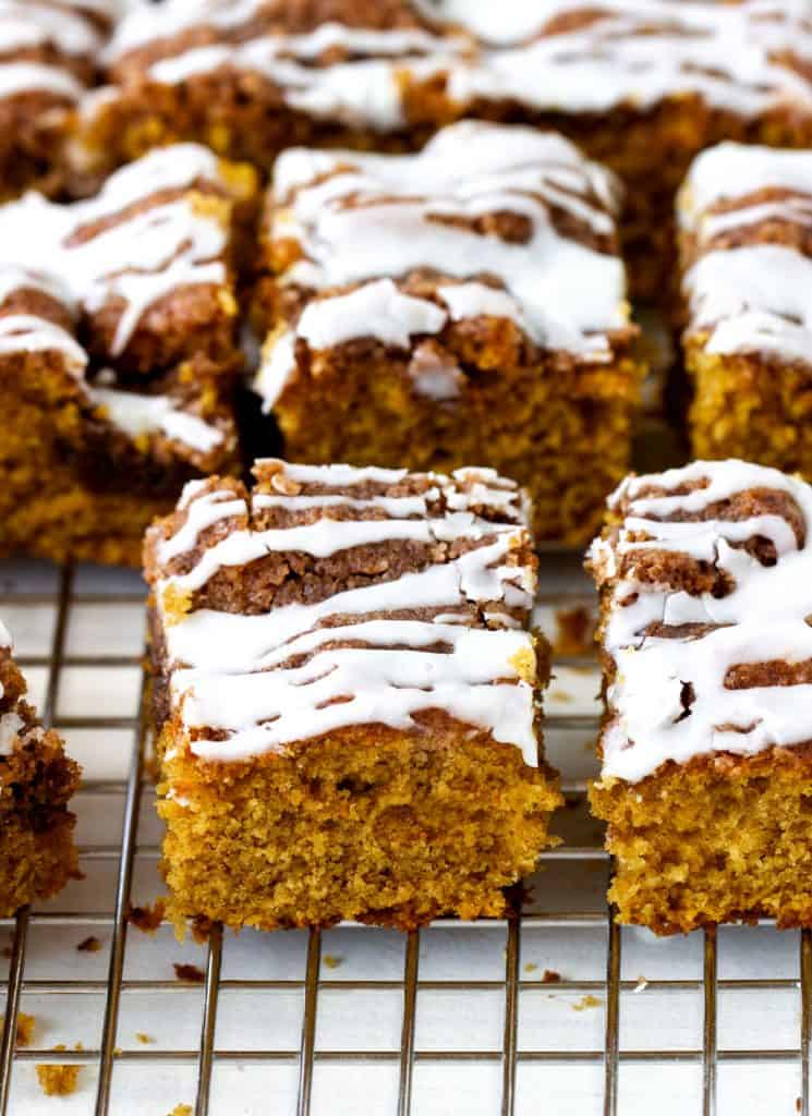Rows of glazed squares of pumpkin cake on wire rack