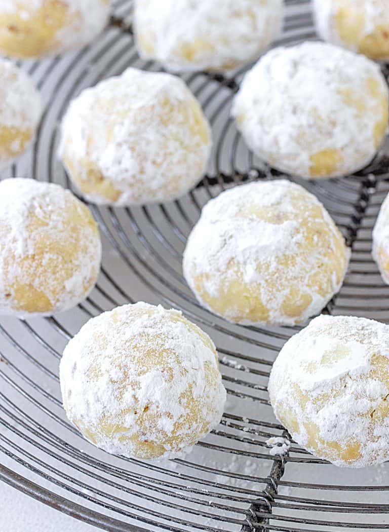 Top view of powdered sugar covered round cookie on wire rack
