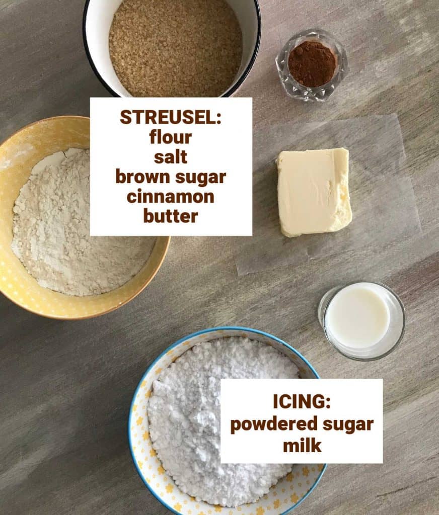 Colored bowls with ingredients for brown sugar cinnamon streusel and powdered sugar icing; brownish surface