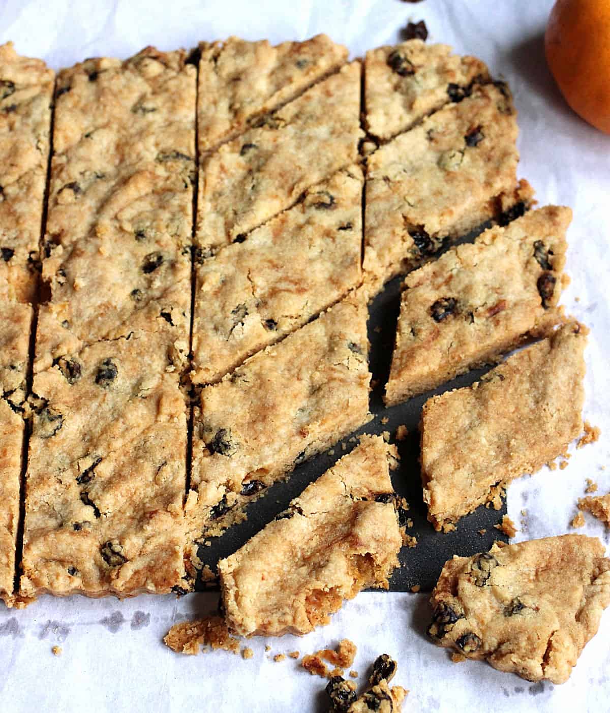 Cut pieces of raisin orange shortbread on a white piece of paper. 